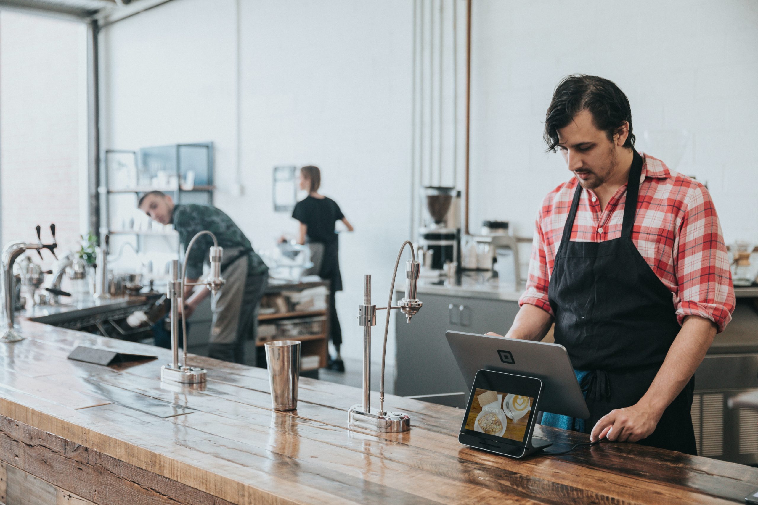 A man stands at the check-out in a coffee shop.