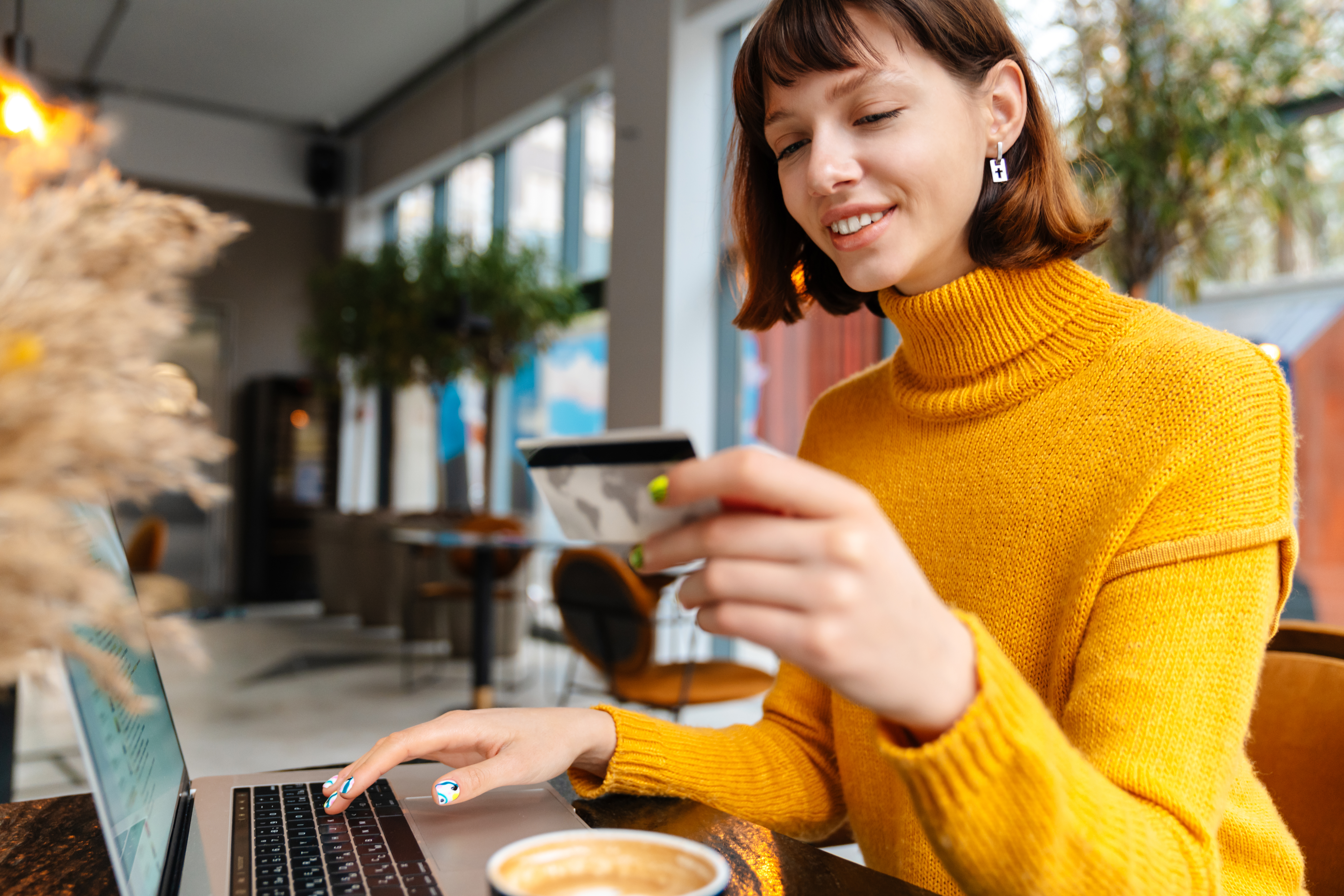 Happy young woman shopping online with credit card